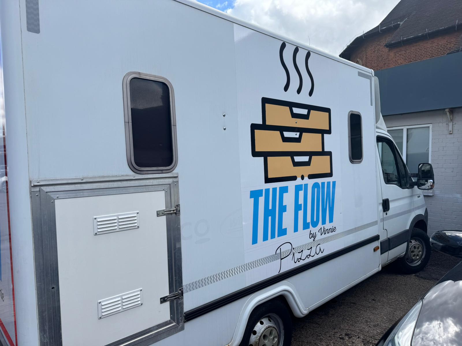 The Flow by Vinnie pizza trailer parked, side view